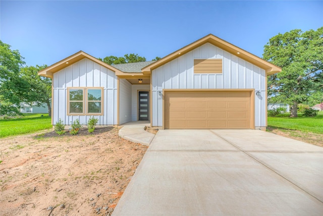 175 Echo Ln, Livingston, TX 77351 - view of front facade featuring board and batten siding, a garage, and driveway