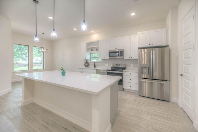 175 Echo Ln, Livingston, TX 77351 - kitchen featuring stainless steel appliances, wood finish floors, a kitchen island, light countertops, and white cabinets