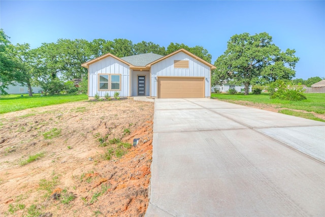 175 Echo Ln, Livingston, TX 77351 - view of front of house with board and batten siding, a garage, driveway, and a front lawn