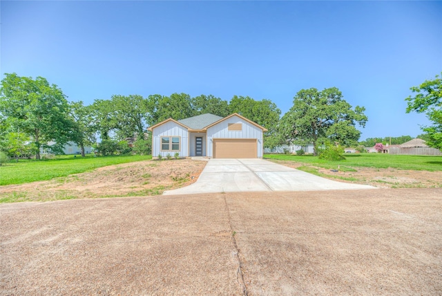 175 Echo Ln, Livingston, TX 77351 - view of front of property with driveway, a garage, board and batten siding, and a front lawn