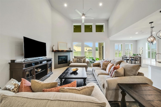 3140 Red Buckeye Ln, Conroe, TX 77301 - living area featuring a towering ceiling, ceiling fan, a glass covered fireplace, recessed lighting, and light wood-type flooring