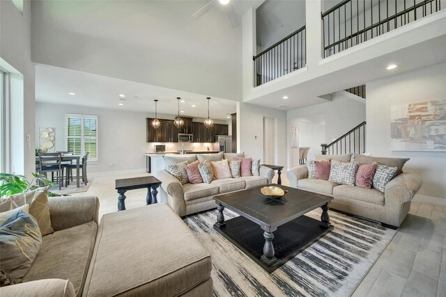 3140 Red Buckeye Ln, Conroe, TX 77301 - living room featuring a towering ceiling, a ceiling fan, stairway, and recessed lighting