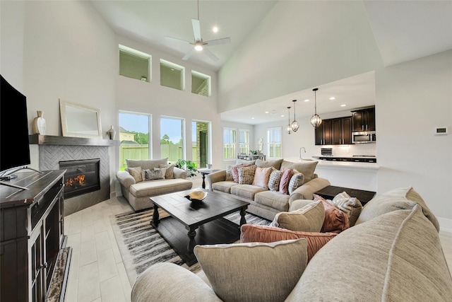 3140 Red Buckeye Ln, Conroe, TX 77301 - living room featuring a fireplace, ceiling fan, a towering ceiling, and recessed lighting