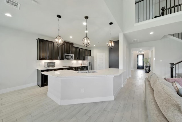 3140 Red Buckeye Ln, Conroe, TX 77301 - kitchen featuring appliances with stainless steel finishes, light wood-type flooring, backsplash, recessed lighting, and open floor plan