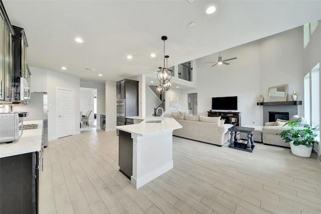 3140 Red Buckeye Ln, Conroe, TX 77301 - kitchen featuring open floor plan, oven, a ceiling fan, light wood-style flooring, and recessed lighting
