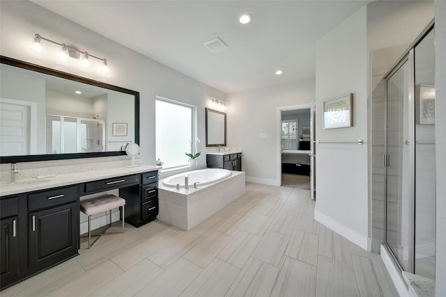 3140 Red Buckeye Ln, Conroe, TX 77301 - ensuite bathroom with a stall shower, a garden tub, two vanities, plenty of natural light, and recessed lighting
