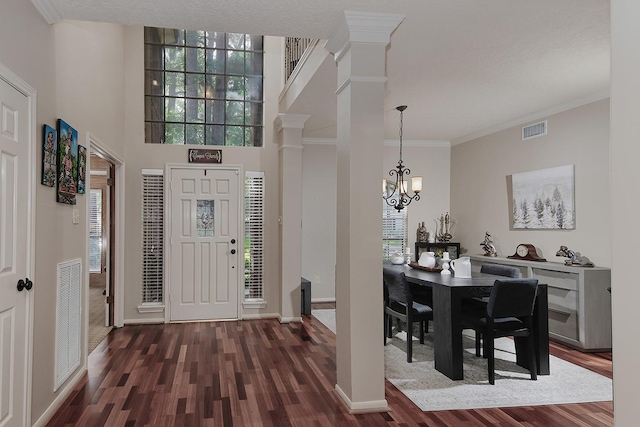 15 Amber Sky Pl, The Woodlands, TX 77381 - foyer entrance featuring dark wood-style floors, a chandelier, plenty of natural light, crown molding, and ornate columns