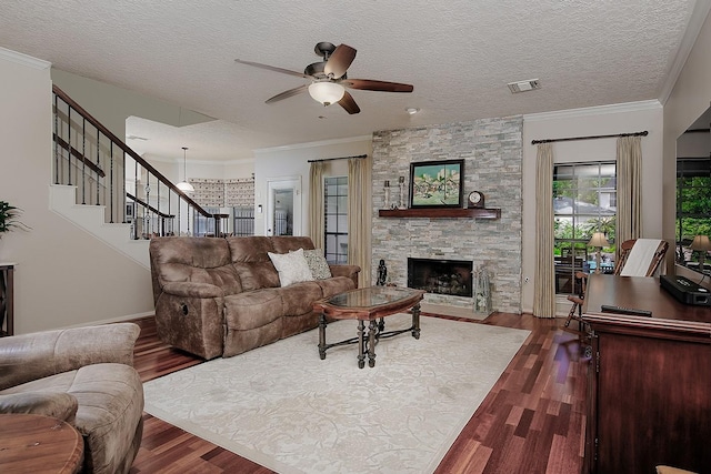 15 Amber Sky Pl, The Woodlands, TX 77381 - living room with dark wood finished floors, ceiling fan, stairs, a stone fireplace, and a textured ceiling