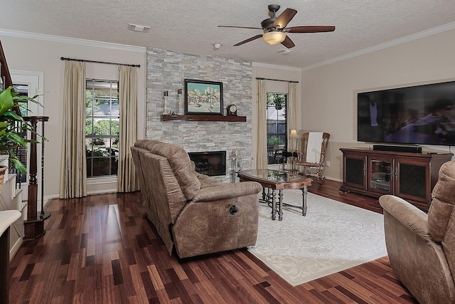 15 Amber Sky Pl, The Woodlands, TX 77381 - living area with healthy amount of natural light, a stone fireplace, wood finished floors, a ceiling fan, and crown molding