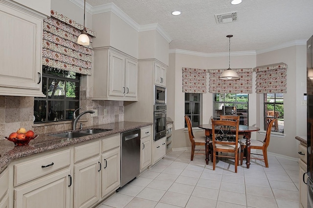 15 Amber Sky Pl, The Woodlands, TX 77381 - kitchen with stainless steel appliances, backsplash, decorative light fixtures, a textured ceiling, and ornamental molding