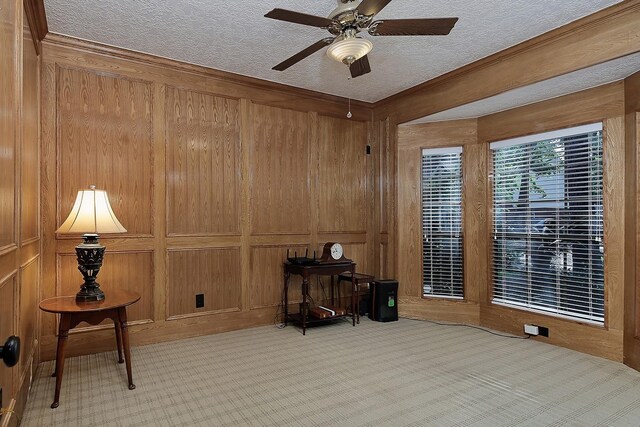 15 Amber Sky Pl, The Woodlands, TX 77381 - sitting room with carpet, ceiling fan, wooden walls, a textured ceiling, and ornamental molding