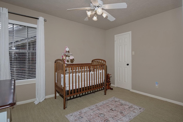 15 Amber Sky Pl, The Woodlands, TX 77381 - bedroom with carpet flooring, a nursery area, ceiling fan, and a textured ceiling