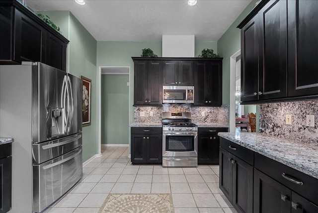 10002 Dawn Brook Dr, Pearland, TX 77584 - kitchen featuring appliances with stainless steel finishes, dark cabinets, and light tile patterned floors