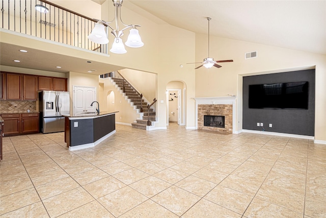 22411 Limestone Crest Ln, Katy, TX 77449 - unfurnished living room with ceiling fan, high vaulted ceiling, a brick fireplace, a chandelier, and light tile patterned floors