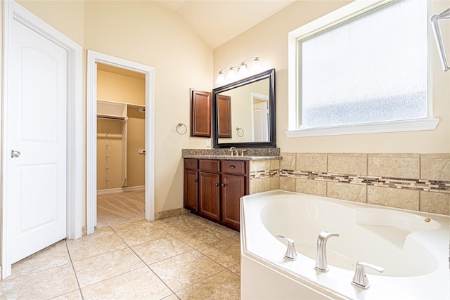 22411 Limestone Crest Ln, Katy, TX 77449 - full bath with vanity, a bath, vaulted ceiling, a spacious closet, and tile patterned floors
