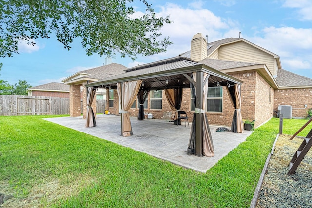 22411 Limestone Crest Ln, Katy, TX 77449 - rear view of house with a gazebo, brick siding, a chimney, a fenced backyard, and roof with shingles