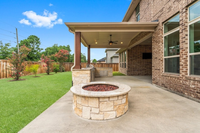 4038 Sabine Valley Trl, Spring, TX 77386 - fenced backyard with ceiling fan, an outdoor fire pit, a patio area, and exterior kitchen