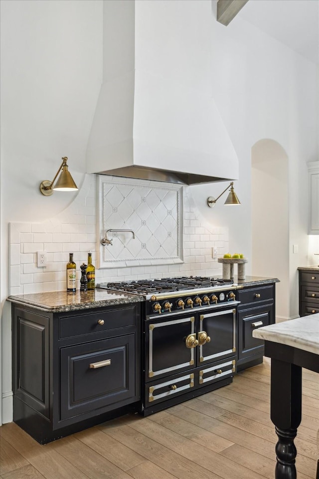 10825 Smithdale Rd, Houston, TX 77024 - kitchen featuring double oven range, premium range hood, light wood-style flooring, and backsplash