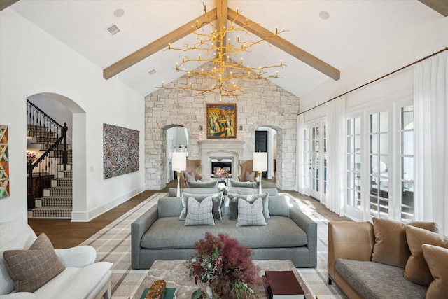 10825 Smithdale Rd, Houston, TX 77024 - living room featuring wood finished floors, beam ceiling, a lit fireplace, arched walkways, and a chandelier