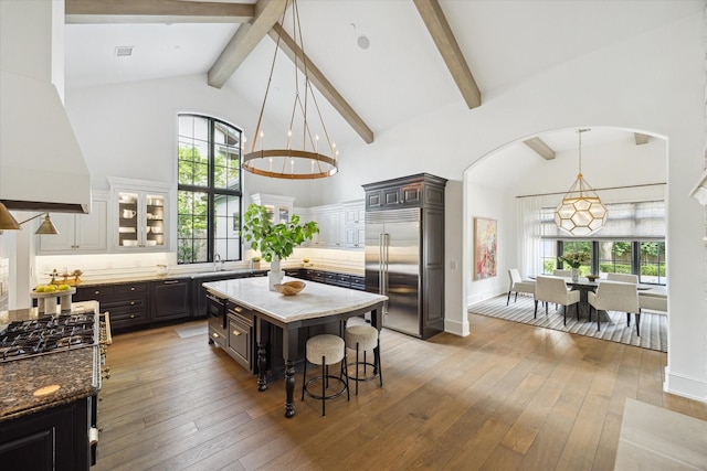 10825 Smithdale Rd, Houston, TX 77024 - kitchen with appliances with stainless steel finishes, custom exhaust hood, beamed ceiling, plenty of natural light, and high vaulted ceiling