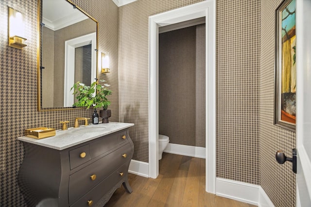 10825 Smithdale Rd, Houston, TX 77024 - bathroom featuring crown molding, wood finished floors, vanity, and wallpapered walls