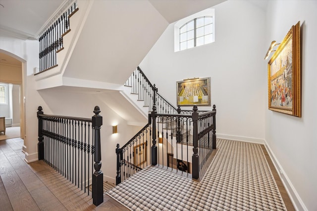 10825 Smithdale Rd, Houston, TX 77024 - stairs with arched walkways, healthy amount of natural light, a towering ceiling, and wood finished floors