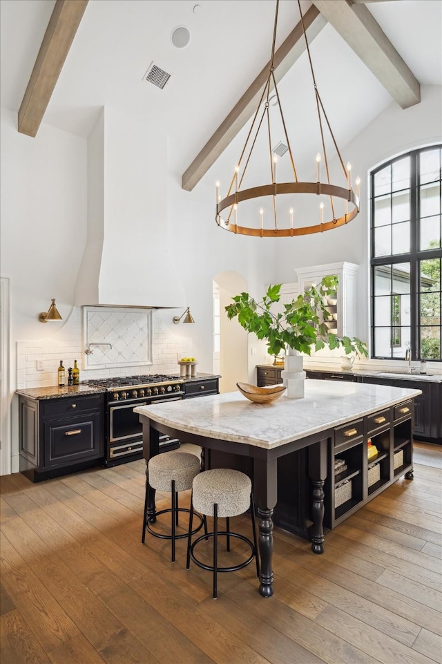 10825 Smithdale Rd, Houston, TX 77024 - dining space featuring beamed ceiling, a chandelier, light wood-type flooring, and high vaulted ceiling