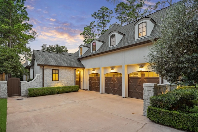 10825 Smithdale Rd, Houston, TX 77024 - french provincial home featuring stucco siding, concrete driveway, stone siding, a gate, and an attached garage