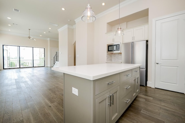 8682 Green Kolbe Ln, Houston, TX 77080 - kitchen with black microwave, freestanding refrigerator, crown molding, a kitchen island, and dark wood finished floors