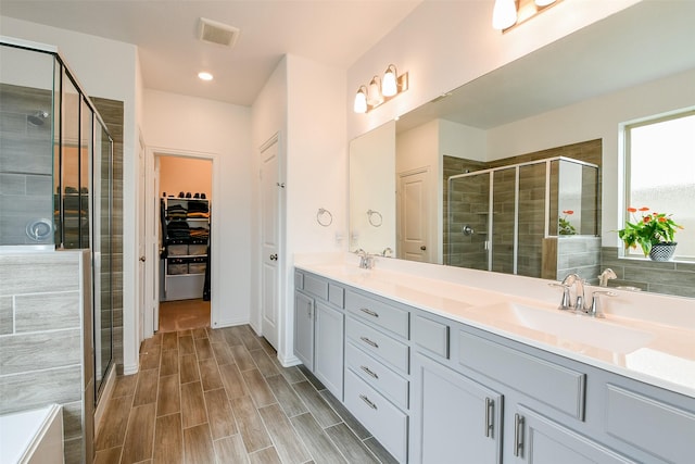 4437 Jessamine Creek Trl, Rosharon, TX 77583 - bathroom featuring a stall shower, double vanity, a walk in closet, and wood finished floors