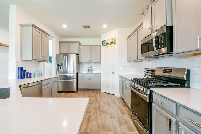 4437 Jessamine Creek Trl, Rosharon, TX 77583 - kitchen with appliances with stainless steel finishes, gray cabinetry, light countertops, decorative backsplash, and recessed lighting