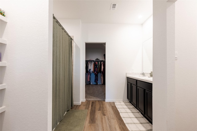 21427 Hawthorn Prairie Dr, New Caney, TX 77357 - full bath featuring wood finished floors, vanity, a walk in closet, and a shower with curtain
