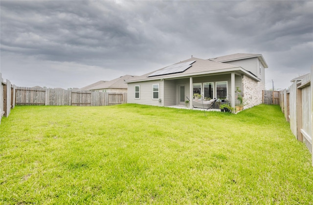 21427 Hawthorn Prairie Dr, New Caney, TX 77357 - rear view of house with roof mounted solar panels, a fenced backyard, and a patio