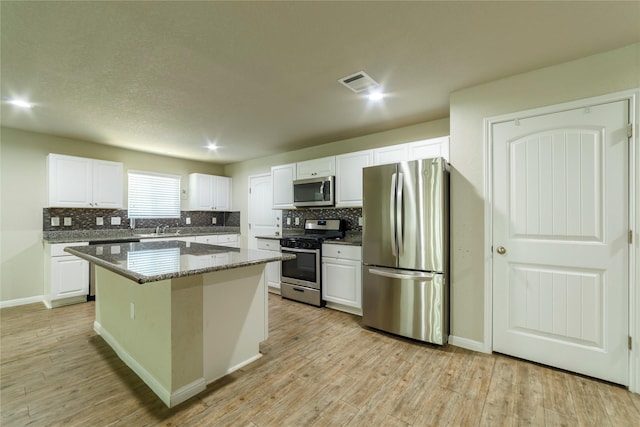 10126 Relic Oaks, San Antonio, TX 78240 - kitchen with appliances with stainless steel finishes, decorative backsplash, white cabinetry, and light wood-style flooring