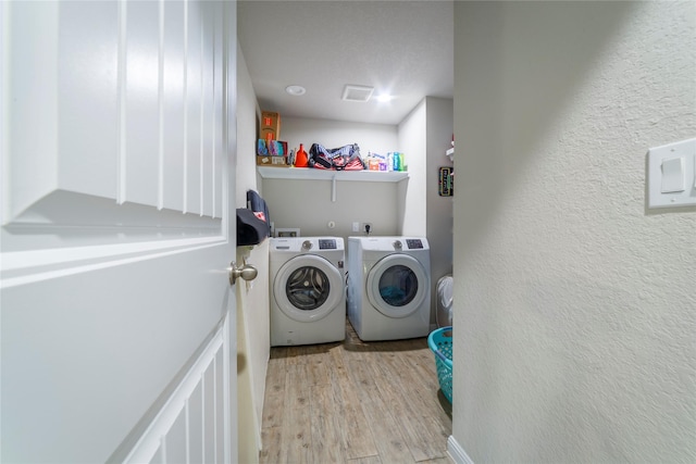 10126 Relic Oaks, San Antonio, TX 78240 - laundry room featuring separate washer and dryer, light wood-style flooring, and a textured wall