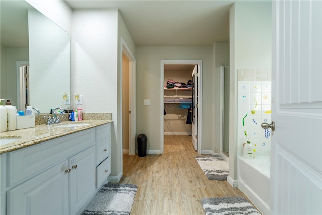 10126 Relic Oaks, San Antonio, TX 78240 - bathroom with double vanity, wood finished floors, a garden tub, a spacious closet, and a shower stall