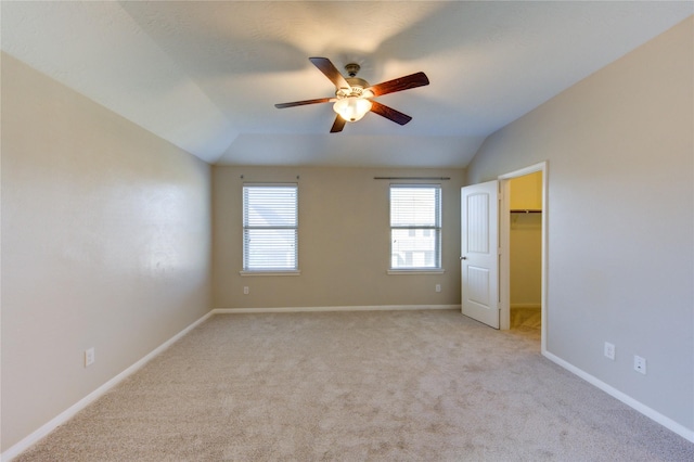 8115 Heartbrook Field Ln, Cypress, TX 77433 - unfurnished bedroom featuring a walk in closet, light carpet, vaulted ceiling, and a ceiling fan