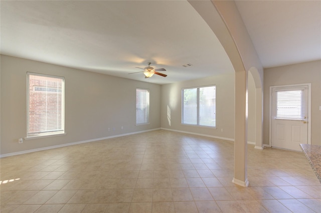 8115 Heartbrook Field Ln, Cypress, TX 77433 - unfurnished room featuring arched walkways, ceiling fan, light tile patterned floors, and plenty of natural light