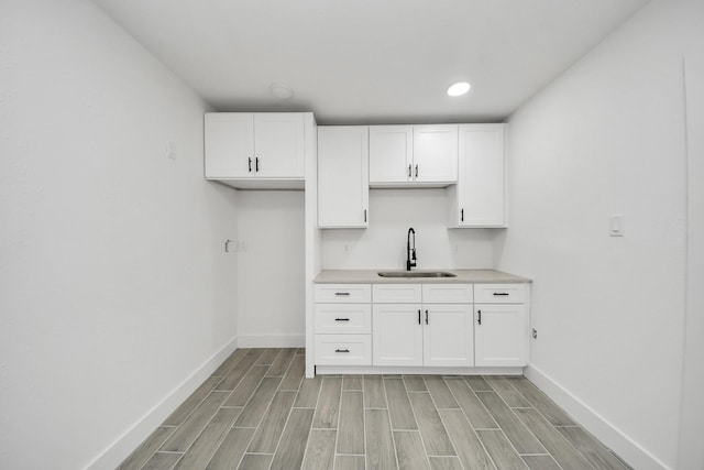 7208 Helmers St, Houston, TX 77022 - kitchen featuring white cabinets, light wood-style flooring, light countertops, and recessed lighting