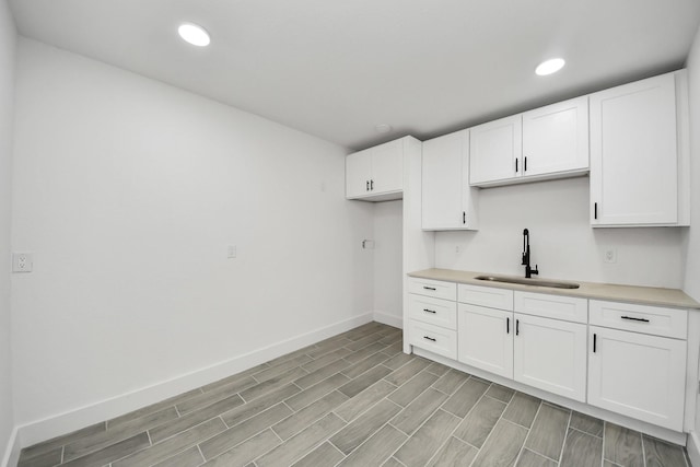 7208 Helmers St, Houston, TX 77022 - kitchen featuring white cabinetry, light countertops, recessed lighting, and light wood-style flooring