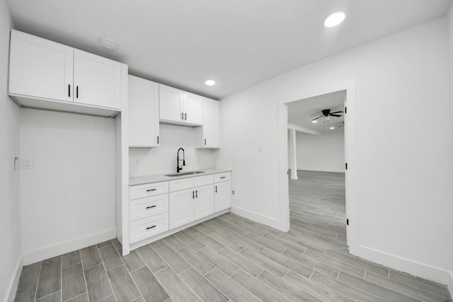 7208 Helmers St, Houston, TX 77022 - kitchen featuring light countertops, white cabinetry, light wood-style flooring, a ceiling fan, and recessed lighting
