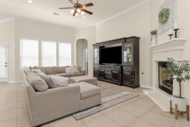 26642 Becker Pines Ln, Katy, TX 77494 - living area with ceiling fan, light tile patterned floors, arched walkways, a glass covered fireplace, and ornamental molding