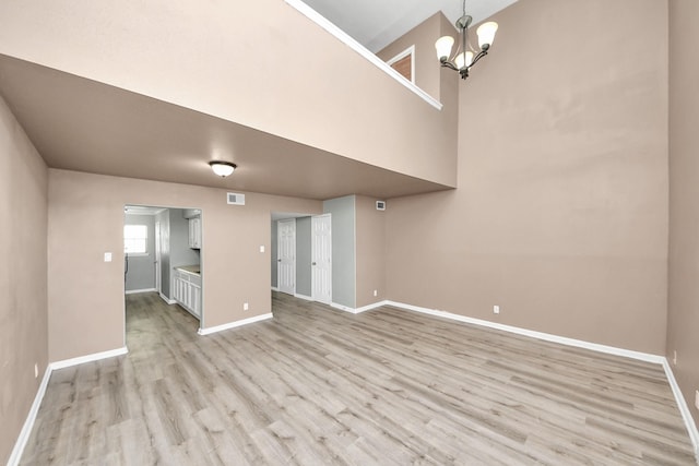 11877 Algonquin Dr, Houston, TX 77089 - unfurnished living room with light wood-style floors, a chandelier, and a towering ceiling