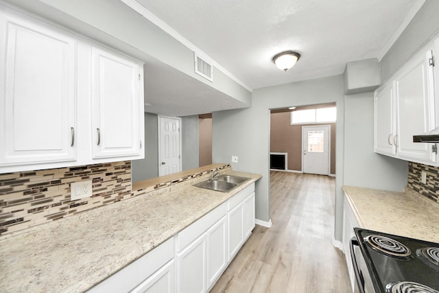 11877 Algonquin Dr, Houston, TX 77089 - kitchen featuring electric range, backsplash, light wood-style flooring, light countertops, and white cabinetry