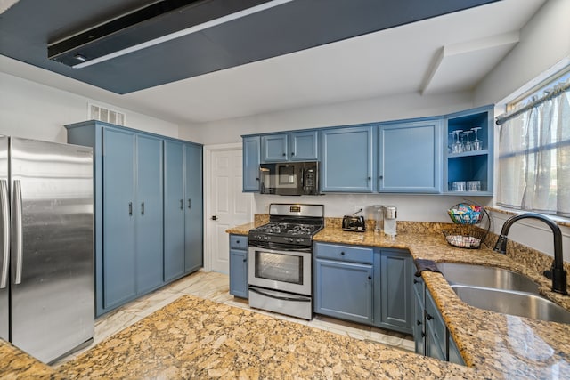 1926 Blodgett St, Houston, TX 77004 - kitchen with stainless steel appliances, blue cabinetry, light stone countertops, and light marble finish flooring