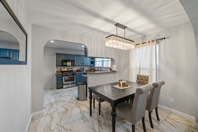 1926 Blodgett St, Houston, TX 77004 - dining room with light marble finish flooring, arched walkways, and a chandelier