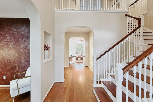 1423 Meadow Lakes Dr, Sugar Land, TX 77479 - entryway featuring wood finished floors, a towering ceiling, arched walkways, stairway, and a ceiling fan