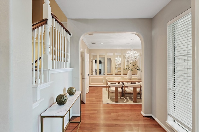 1423 Meadow Lakes Dr, Sugar Land, TX 77479 - corridor with arched walkways, light wood-style flooring, ornamental molding, a chandelier, and stairs