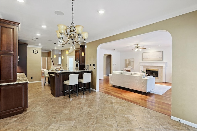 1423 Meadow Lakes Dr, Sugar Land, TX 77479 - kitchen with arched walkways, a breakfast bar area, oven, a ceiling fan, and crown molding