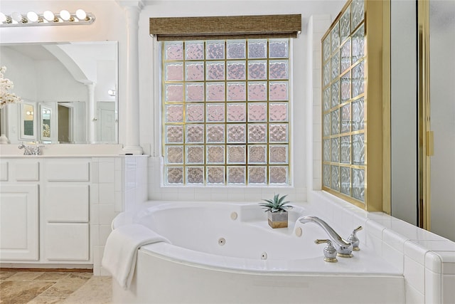 1423 Meadow Lakes Dr, Sugar Land, TX 77479 - bathroom with ornate columns, a jetted tub, vanity, and stone finish flooring